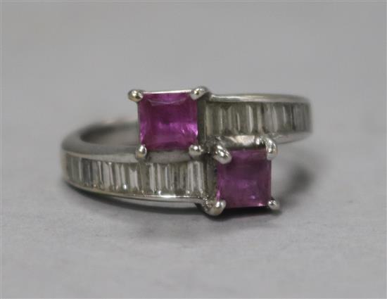 An 18ct white gold pink sapphire and baguette cut diamond crossover ring, 6g gross